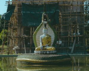 a statue of a buddha sitting on top of a large tire