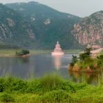 body of water near green mountain during daytime